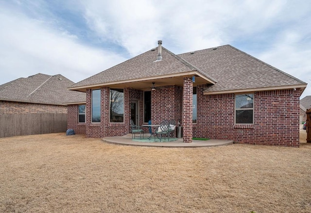 back of house with a patio, a lawn, brick siding, and a shingled roof