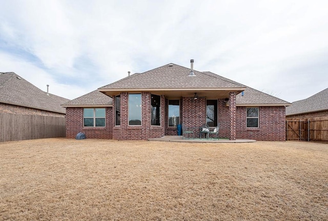 back of property featuring a fenced backyard, roof with shingles, brick siding, ceiling fan, and a patio area