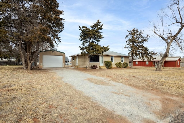 ranch-style house with a garage and an outbuilding