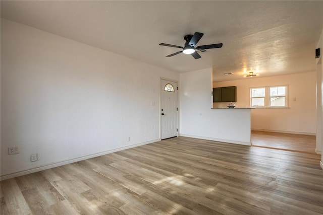 unfurnished living room with hardwood / wood-style flooring and ceiling fan