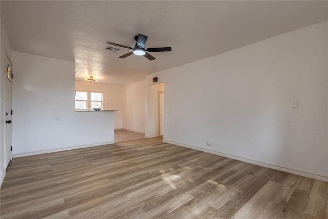 empty room with ceiling fan and light hardwood / wood-style flooring