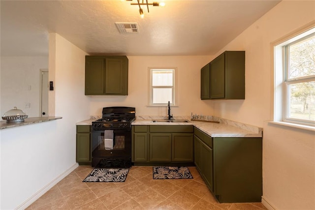 kitchen featuring sink, light tile patterned floors, black range with gas stovetop, and green cabinetry