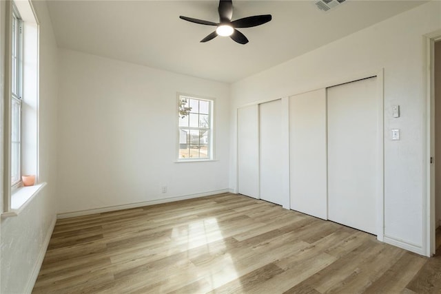 unfurnished bedroom featuring ceiling fan, light hardwood / wood-style flooring, and a closet