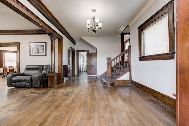 foyer featuring dark hardwood / wood-style floors, crown molding, and a chandelier