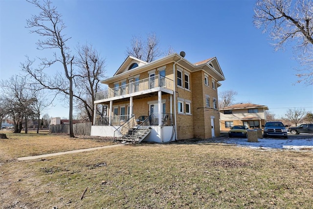 view of front of house with a front lawn and a balcony