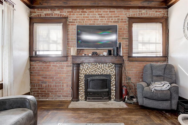 living room with brick wall, dark parquet flooring, and ornamental molding