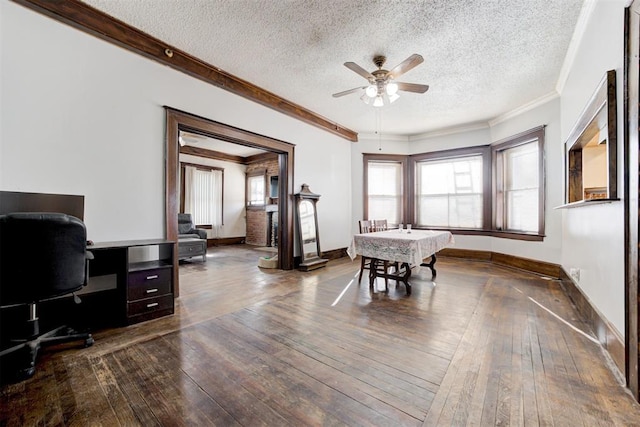 office area with ceiling fan, a textured ceiling, dark hardwood / wood-style flooring, and crown molding