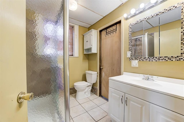 bathroom featuring an enclosed shower, vanity, tile patterned flooring, and toilet