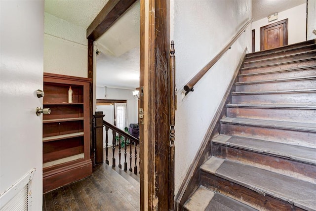 stairway featuring hardwood / wood-style floors and a textured ceiling