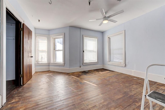 spare room with ceiling fan and dark wood-type flooring