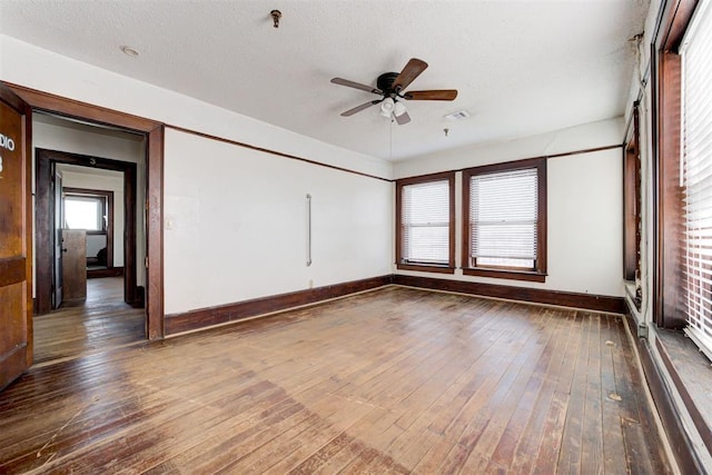 unfurnished room featuring a textured ceiling, ceiling fan, and dark hardwood / wood-style floors