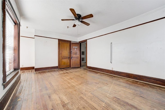 spare room with ceiling fan, wood-type flooring, and plenty of natural light