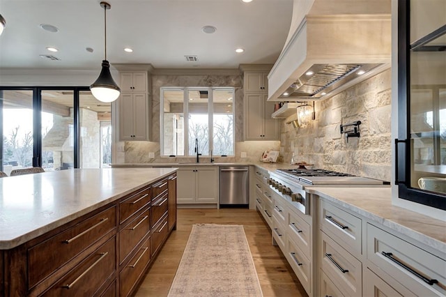 kitchen with decorative backsplash, appliances with stainless steel finishes, white cabinetry, and pendant lighting