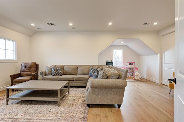 living room with light wood-type flooring and lofted ceiling