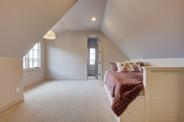 bedroom with light colored carpet and vaulted ceiling