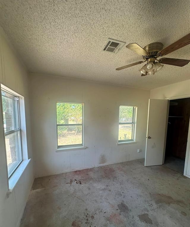 unfurnished room featuring ceiling fan and a textured ceiling