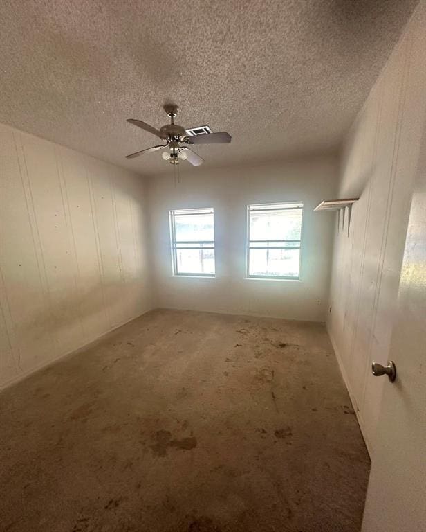 spare room featuring ceiling fan and a textured ceiling