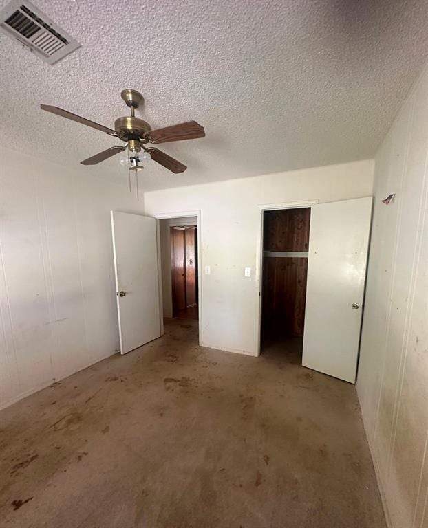 unfurnished bedroom with ceiling fan and a textured ceiling