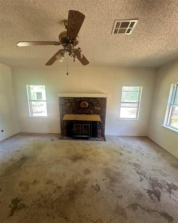 unfurnished living room with a wealth of natural light, carpet flooring, and a fireplace