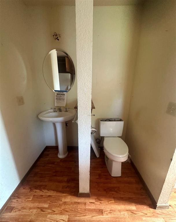 bathroom featuring hardwood / wood-style flooring and toilet