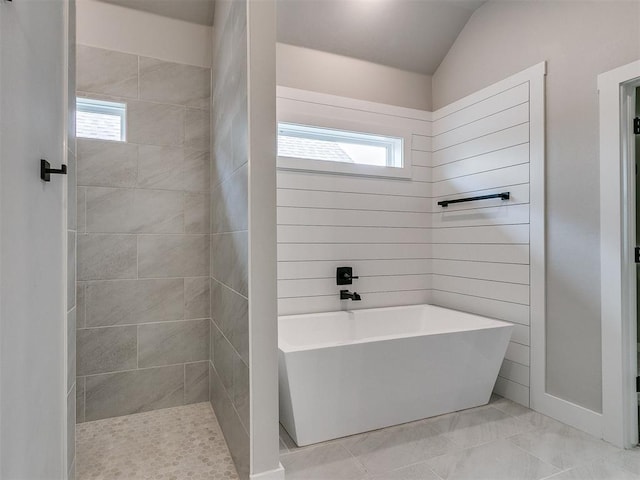 full bathroom with a freestanding bath and lofted ceiling