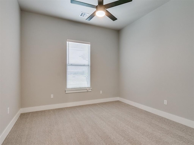 spare room featuring ceiling fan, carpet floors, visible vents, and baseboards