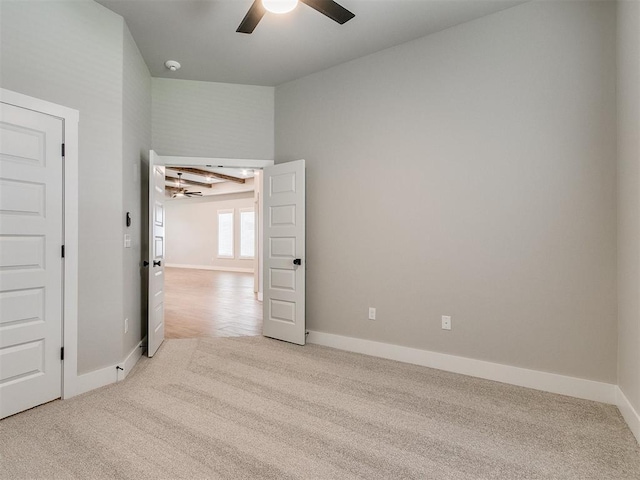 unfurnished room featuring light colored carpet, ceiling fan, and baseboards