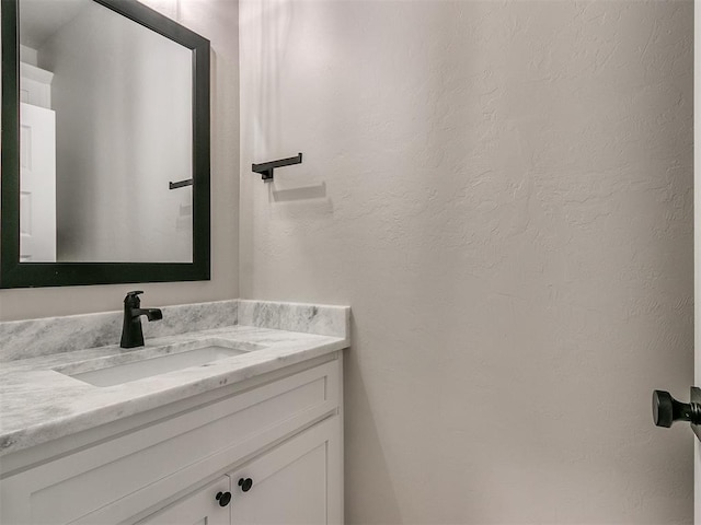 bathroom featuring a textured wall and vanity