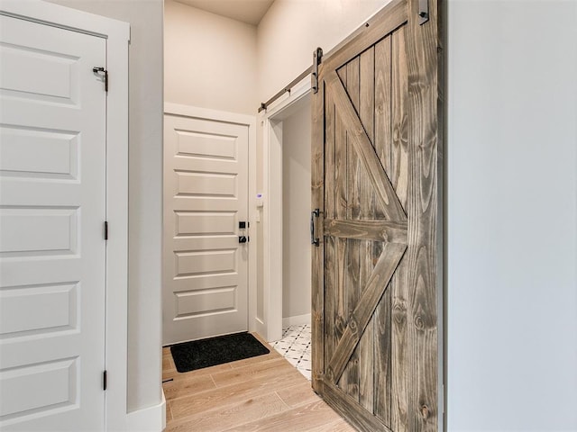 foyer entrance featuring light wood-style floors and a barn door