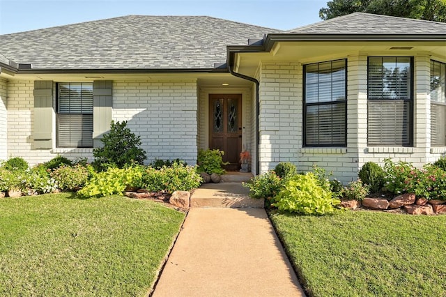 view of exterior entry featuring a yard