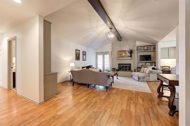 living room featuring a fireplace, light hardwood / wood-style floors, vaulted ceiling with beams, built in features, and a chandelier