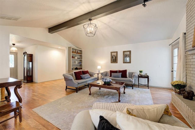 living room featuring light hardwood / wood-style floors, an inviting chandelier, lofted ceiling with beams, and a healthy amount of sunlight