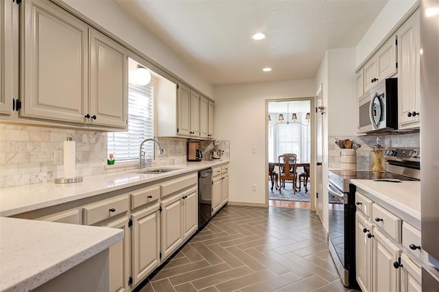 kitchen with a wealth of natural light, stainless steel appliances, decorative backsplash, and sink