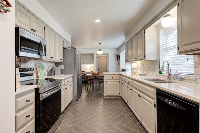 kitchen with appliances with stainless steel finishes, sink, backsplash, and decorative light fixtures