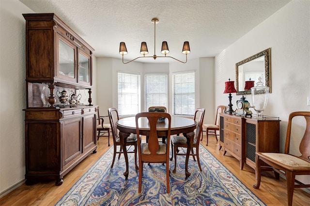 dining space featuring a textured ceiling and light hardwood / wood-style flooring