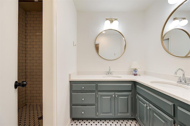 bathroom featuring vanity, tile patterned flooring, and tiled shower