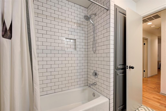 bathroom featuring wood-type flooring and shower / bath combo