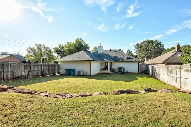 back of house with central AC and a yard