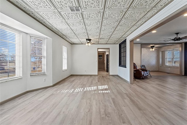 unfurnished living room with light hardwood / wood-style floors, ceiling fan, and a healthy amount of sunlight