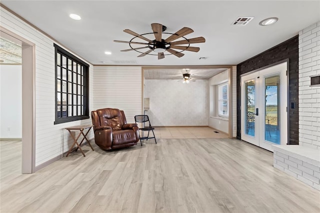 living area with ceiling fan and light hardwood / wood-style flooring