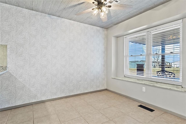 tiled spare room featuring ceiling fan and wooden ceiling