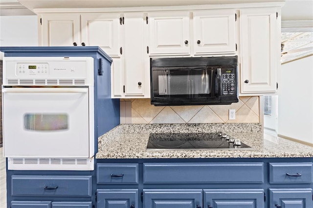 kitchen featuring white cabinets, tasteful backsplash, blue cabinetry, light stone counters, and black appliances