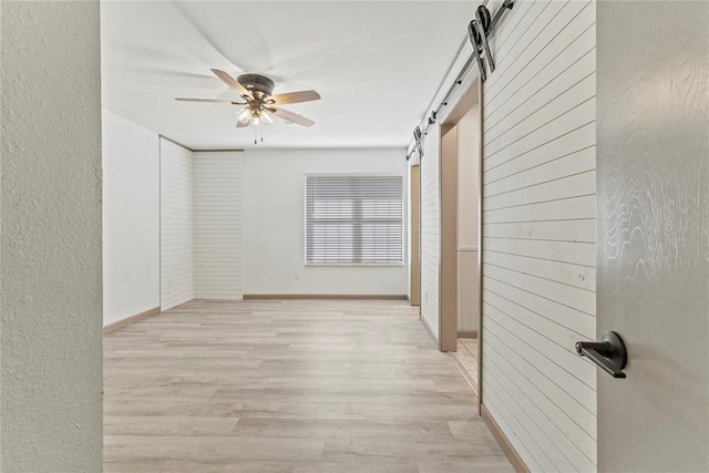 interior space with light wood-type flooring and a barn door