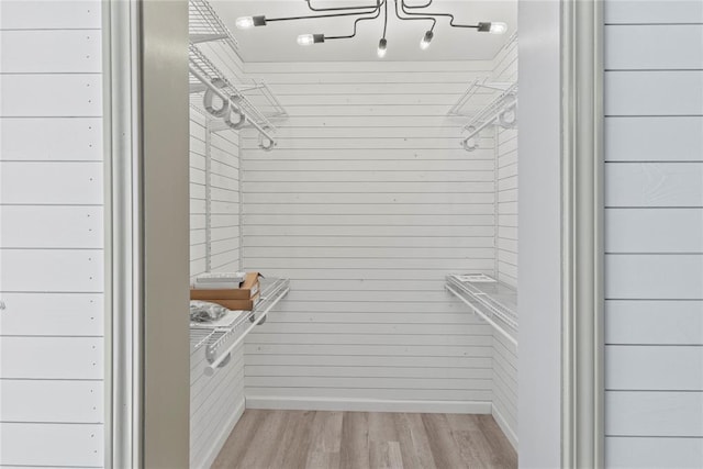 walk in closet with light hardwood / wood-style floors