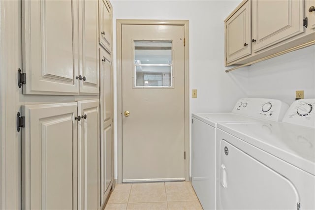 washroom with washing machine and dryer, light tile patterned floors, and cabinets