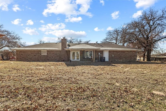 back of property featuring central AC unit, a lawn, and french doors