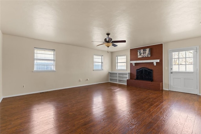 unfurnished living room with a brick fireplace, plenty of natural light, and hardwood / wood-style floors