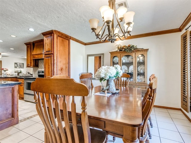 dining area with crown molding, a chandelier, a textured ceiling, and light tile patterned floors