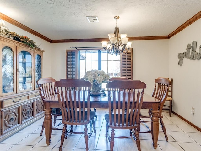 tiled dining area with a textured ceiling, crown molding, and an inviting chandelier