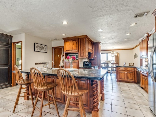 kitchen featuring stainless steel appliances, a notable chandelier, light tile patterned floors, crown molding, and a breakfast bar area